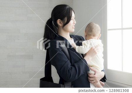 Working mother holding a baby Working mother holding a baby 128981308