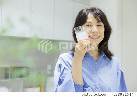 一個女人在廚房喝水 128981514