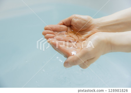 女人的手舀熱水 女人的手舀熱水 128981826