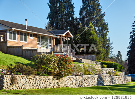 Family residential house on land terrace in sunset rays in British Columbia 128981935