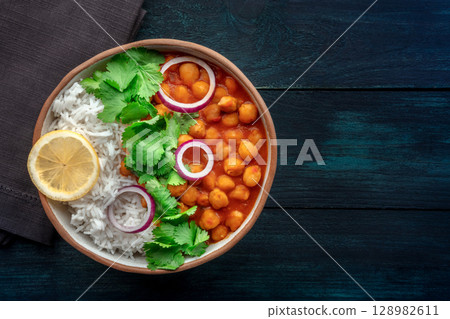Chana masala, chickpea curry, traditional Indian dish, overhead flat lay shot Chana masala, chickpea curry, traditional Indian dish, overhead flat lay shot 128982611
