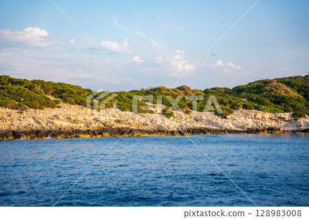 Uninhabited islands of the Lastovo National Park surrounded by calm sea in Croatia. Nature reserve, remote landscape and Mediterranean summer escape Uninhabited islands of the Lastovo National Park surrounded by calm sea in Croatia. Nature reserve, remote landscape and Mediterranean summer escape 128983008