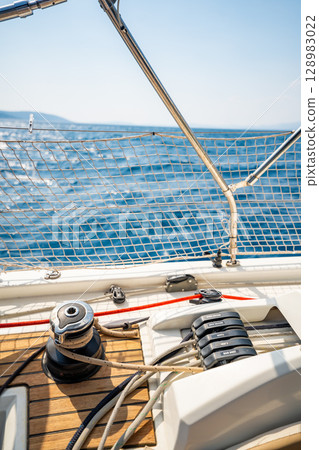 Close-up of rope clutches and winches on the deck of a sailing yacht near Croatia. Sailing equipment, control systems and technical detail of life at sea. 128983022