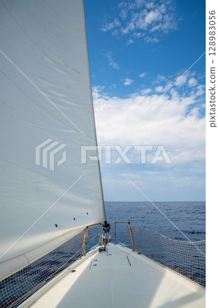 Bow of a sailing yacht cutting through the sea with sails fully open near Croatia. Freedom, motion, clean energy and slow travel on the open water. Bow of a sailing yacht cutting through the sea with sails fully open near Croatia. Freedom, motion, clean energy and slow travel on the open water. 128983056