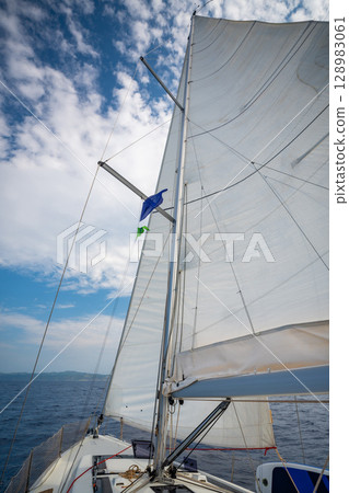 Sailing yacht moving at full speed with all sails up in the open sea near Croatia. Dynamic maritime adventure and freedom of ocean travel. 128983061