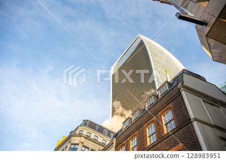 Fenchurch Building, known as the Walkie-Talkie, stands out against a clear sky in the heart of London's financial district, blending modern architecture with historic buildings. Fenchurch Building, known as the Walkie-Talkie, stands out against a clear sky in the heart of London's financial district, blending modern architecture with historic buildings. 128983951