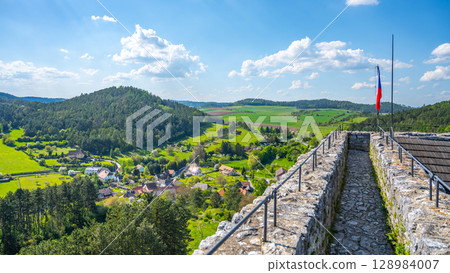 Visitors enjoy a panoramic view from the Donjon Tower of Rabi Castle in Czechia. The lush green landscape stretches across the horizon, showcasing rolling hills and quaint villages below. Visitors enjoy a panoramic view from the Donjon Tower of Rabi Castle in Czechia. The lush green landscape stretches across the horizon, showcasing rolling hills and quaint villages below. 128984007