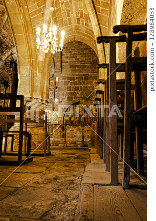 Interior of the Bella Pais Monastery in the Turkish Republic of Northern Cyprus. Religious paintings and armchairs. 128984033