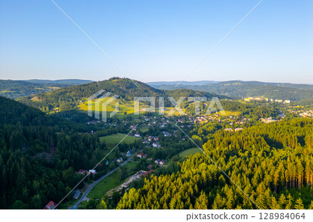 Stunning aerial perspective of Tanvaldsky Spicak showcases the lush greenery and rolling hills of the Jizera Mountains in Czechia. Stunning aerial perspective of Tanvaldsky Spicak showcases the lush greenery and rolling hills of the Jizera Mountains in Czechia. 128984064