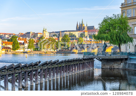 The statue of Bedrich Smetana stands proudly along the river, providing a view of Prague's beautiful architecture and landmarks. A tranquil moment captures the essence of the city. The statue of Bedrich Smetana stands proudly along the river, providing a view of Prague's beautiful architecture and landmarks. A tranquil moment captures the essence of the city. 128984078