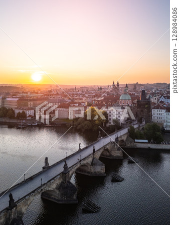 Early morning light casts a warm glow over Charles Bridge and the Vltava River, showcasing the beauty of Prague's skyline and historic architecture in a quiet moment. Early morning light casts a warm glow over Charles Bridge and the Vltava River, showcasing the beauty of Prague's skyline and historic architecture in a quiet moment. 128984086