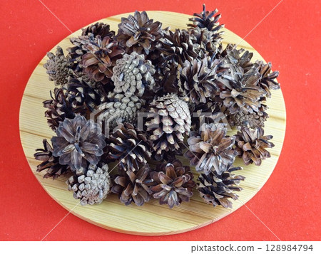 New Year's set for creativity. Natural pine cones of medium size on a wooden board. Top view New Year's set for creativity. Natural pine cones of medium size on a wooden board. Top view 128984794