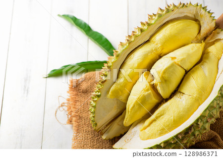 Durian fruit. Ripe monthong durian on sack and white wood background, king of fruit from Thailand on summer Durian fruit. Ripe monthong durian on sack and white wood background, king of fruit from Thailand on summer 128986371
