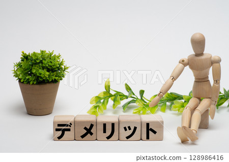 A drawing doll pointing to the word "demerit" 128986416