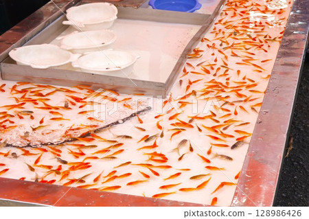 Goldfish scooping at festival stall 1 Goldfish scooping at festival stall 1 128986426
