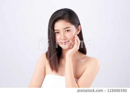 A beautiful young Asian woman with clean, fresh skin against a white background. Skincare, facial treatment, cosmetology, beauty, and spa. An elegant portrait of an Asian woman. A beautiful young Asian woman with clean, fresh skin against a white background. Skincare, facial treatment, cosmetology, beauty, and spa. An elegant portrait of an Asian woman. 128986580