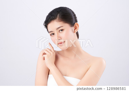 A beautiful young Asian woman with clean, fresh skin against a white background. Skincare, facial treatment, cosmetology, beauty, and spa. An elegant portrait of an Asian woman. A beautiful young Asian woman with clean, fresh skin against a white background. Skincare, facial treatment, cosmetology, beauty, and spa. An elegant portrait of an Asian woman. 128986581