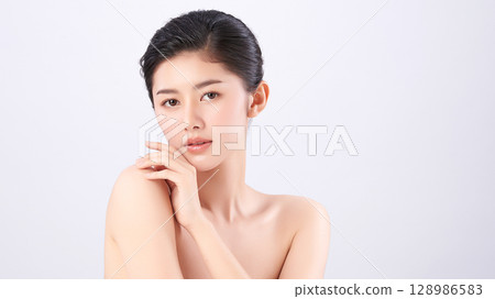A beautiful young Asian woman with clean, fresh skin against a white background. Skincare, facial treatment, cosmetology, beauty, and spa. An elegant portrait of an Asian woman. A beautiful young Asian woman with clean, fresh skin against a white background. Skincare, facial treatment, cosmetology, beauty, and spa. An elegant portrait of an Asian woman. 128986583