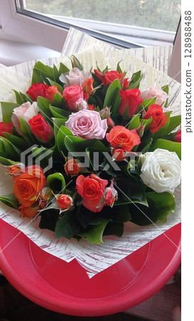 Mixed Bouquet of Red, Pink, and White Roses on a Pink Tray by a Sunlit Window 128988488