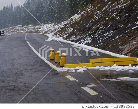 Yellow road closed barrier blocking dangerous snow ice weather covered road Yellow road closed barrier blocking dangerous snow ice weather covered road 128988582