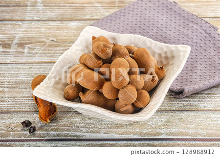 Tropical exotic Tamarind fruit heap 128988912