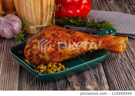 Baked turkey drumstick served green peas 128988949