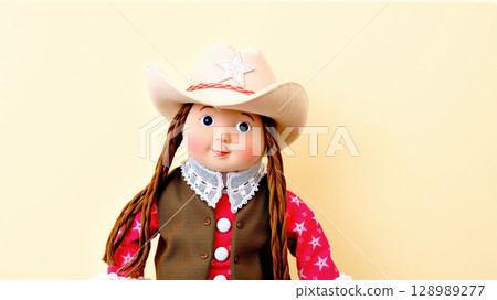 Cowgirl doll with braided hair and western outfit on yellow background 128989277