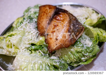 Grilled fish salad with sauce served on plate Grilled fish salad with sauce served on plate 128989367