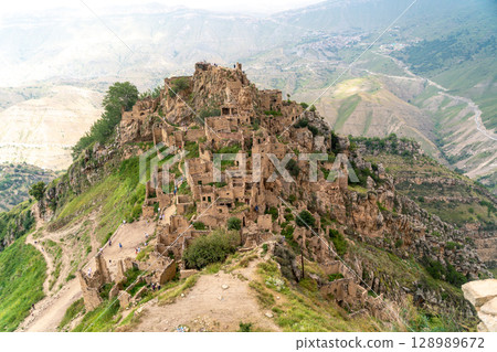 Dagestan Gamsutl. Ancient ghost town of Gamsutl old stone houses in abandoned Gamsutl mountain village in Dagestan, Abandoned etnic aul, summer landscape. Dagestan Gamsutl. Ancient ghost town of Gamsutl old stone houses in abandoned Gamsutl mountain village in Dagestan, Abandoned etnic aul, summer landscape. 128989672