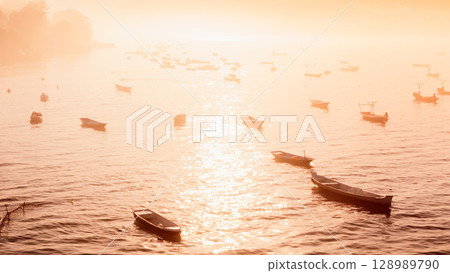 Scenic view of seaweed farm with boats in Lembongan island in Indonesia. Algae farm with morning warm sun light 128989790