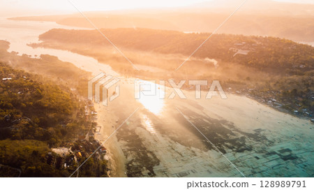 Nusa Lembongan and Nusa Ceningan bridge. Drone view of a bridge connecting two islands over a narrow ocean channel. 128989791