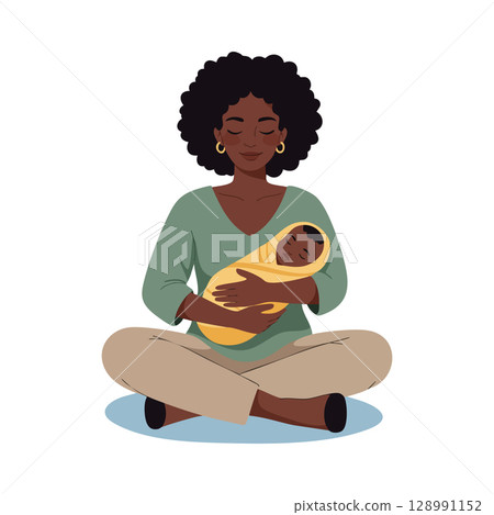 African American mother holding baby wrapped in yellow blanket sitting cross legged calm moment 128991152