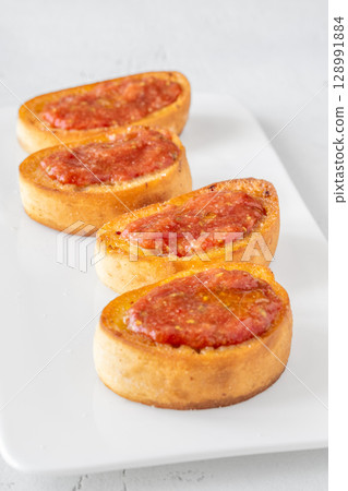 Traditional Pan con Tomate Sandwiches Served on White Plate with Rustic Style Traditional Pan con Tomate Sandwiches Served on White Plate with Rustic Style 128991884