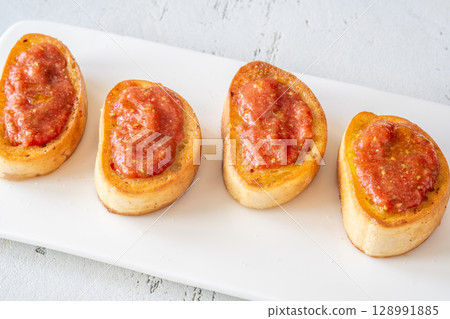 Traditional Pan con Tomate Sandwiches Served on White Plate with Rustic Style Traditional Pan con Tomate Sandwiches Served on White Plate with Rustic Style 128991885