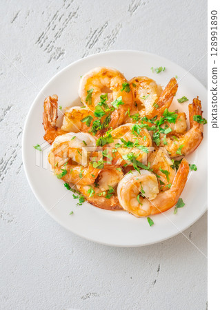 Golden Spanish Fried Shrimps Garnished with Fresh Parsley on White Background Plate Golden Spanish Fried Shrimps Garnished with Fresh Parsley on White Background Plate 128991890