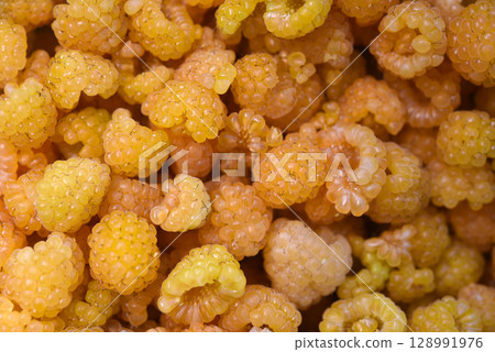 Yellow raspberries in close-up. Juicy sweet yellow berries. Yellow raspberries in close-up. Juicy sweet yellow berries. 128991976