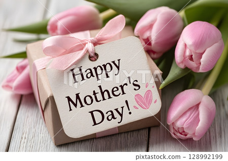 Pink tulips gracefully surround a heartfelt gift box with a Happy Mother's Day tag. This beautiful arrangement symbolizes love and appreciation for a special mother. 128992199