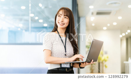 微笑的女人在辦公室使用電腦 微笑的女人在辦公室使用電腦 128992279