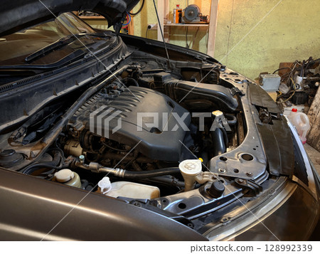A detailed view of a powerful car engine, showcasing its complex mechanical components and engineering A detailed view of a powerful car engine, showcasing its complex mechanical components and engineering 128992339