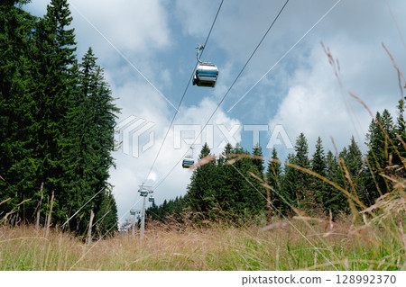 21 July 2025, Cerna Hora in Janskie Lazne, Czech Republic. Cableway System on Cerna Hora mountain. A beautiful sunny summer day. Cabin lift visible from the meadow. 21 July 2025, Cerna Hora in Janskie Lazne, Czech Republic. Cableway System on Cerna Hora mountain. A beautiful sunny summer day. Cabin lift visible from the meadow. 128992370