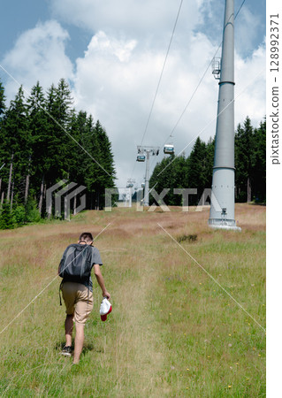 21 July 2025, Cerna Hora in Janskie Lazne, Czech Republic. Cableway System on Cerna Hora mountain. A beautiful sunny summer day. Cabin lift visible from the meadow. 128992371