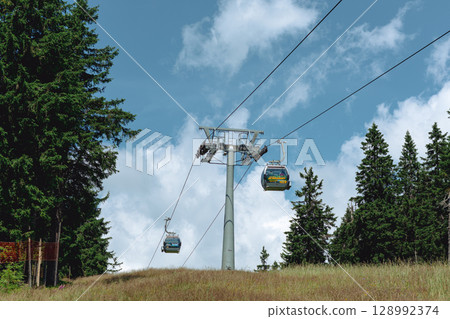 21 July 2025, Cerna Hora in Janskie Lazne, Czech Republic. Cableway System on Cerna Hora mountain. A beautiful sunny summer day. Cabin lift visible from the meadow. 128992374