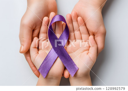 Hands of different generations gently hold a purple awareness ribbon. This symbolizes global solidarity and support, offering universal hope in the fight against cancer worldwide. 128992579
