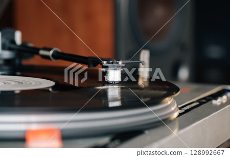 Close-up of a cartridge head on a vinyl record, analog retro music, vinyl disc collecting, vintage equipment Close-up of a cartridge head on a vinyl record, analog retro music, vinyl disc collecting, vintage equipment 128992667