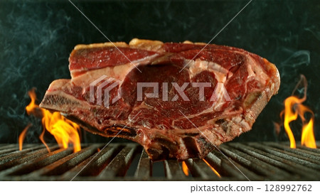 Close-up of Beef Steak on a Grill with Roaring Flames Close-up of Beef Steak on a Grill with Roaring Flames 128992762