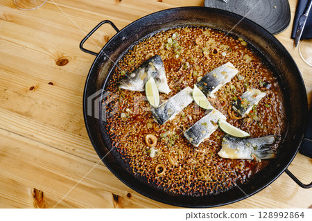 sea bass paella served in the paella pan 128992864