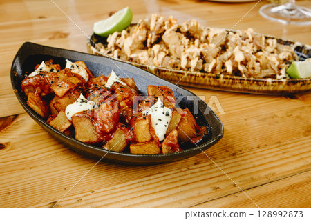 spanish patatas bravas and chipirones tapas 128992873