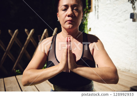 Middle-Aged Woman Practicing Mindfulness Meditation Outdoors in Natural Light Middle-Aged Woman Practicing Mindfulness Meditation Outdoors in Natural Light 128992933