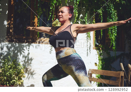 Active Woman Practicing Yoga Outdoors in a Peaceful Garden Setting Active Woman Practicing Yoga Outdoors in a Peaceful Garden Setting 128992952