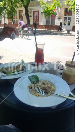 Summer Lunch Al Fresco: Pasta, Salad, and Beverage on Patio 128993497